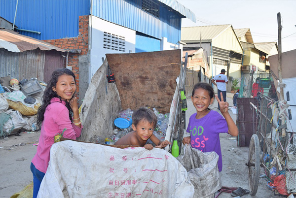 カンボジアスラムで家のお手伝いでゴミを拾う子供たち