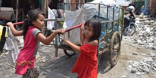 カンボジアのスラムでゴミを運ぶ少女たち
