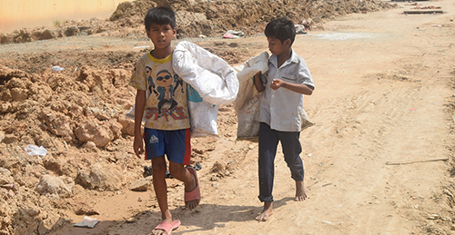 カンボジアのスラムでゴミを拾う少年たち