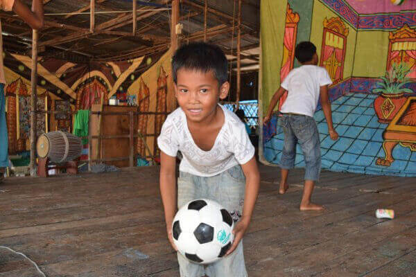 サッカーボールを持つバッサク孤児院の少年