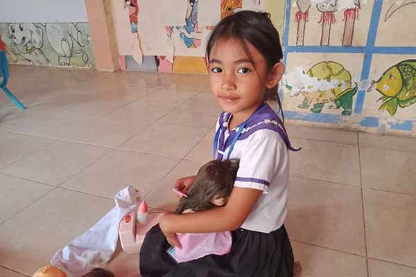 ぽぽちゃんのお世話をするカンボジアの女の子