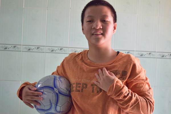 サッカーボールを小脇に抱える施設の子供