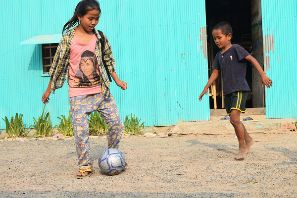 サッカーをする少女と少年