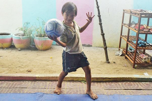 ボールを持ってポーズする孤児院の少年