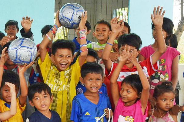 サッカーボールにうれしそうに手を挙げる子供たち